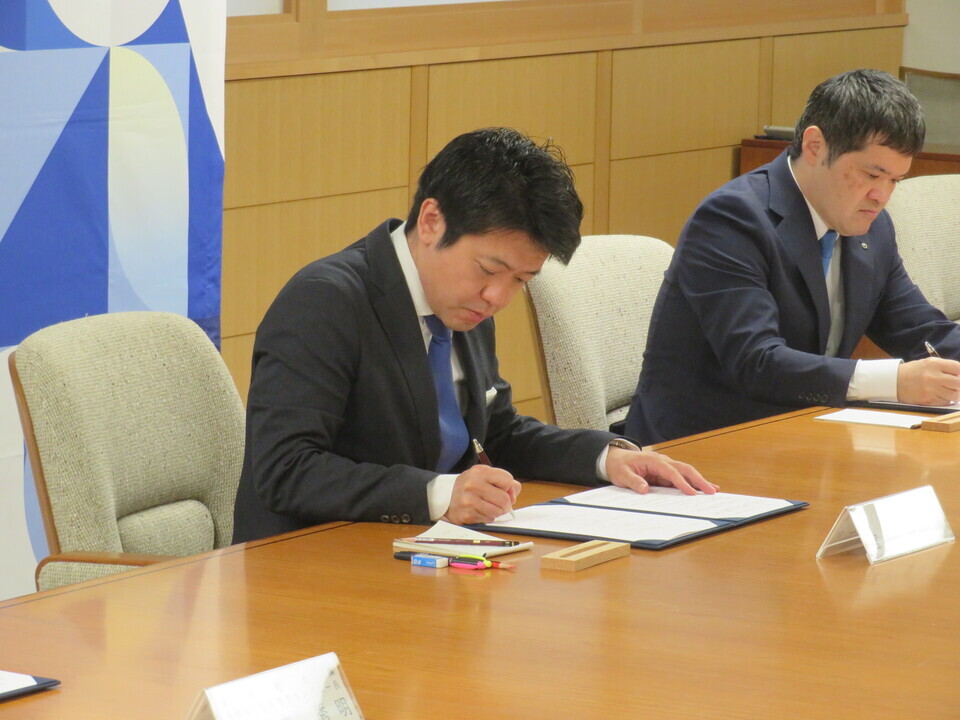 写真：署名する知事